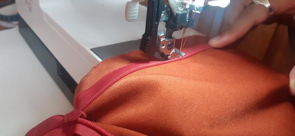 Couture de la fermeture éclair sur le derière de la robe.