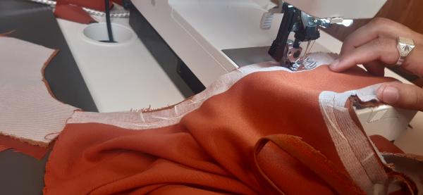 Couture de la doublure sur la robe.