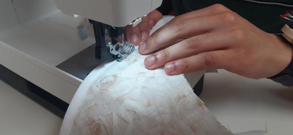 Dans ce vêtement, nous ne surjetons pas les bords. Il y a tellement de bords nus, visibles à l'intérieur de la veste, que l'on ne peut tout simplement pas surjeter seulement. Il y aurait beaucoup trop de fibres.<br>À la place, j'utilise ici un bias blanc qui rend les bords propre, et ainsi je suis sur que le tissu ne pourra pas s'effilocher avec le temps et les frictions.