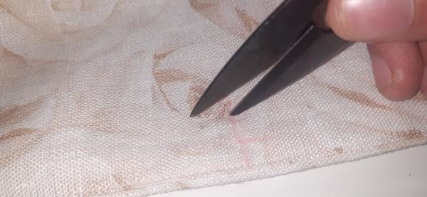 Ici, je fais des incisions dans le tissu pour placer mes boutons pression.