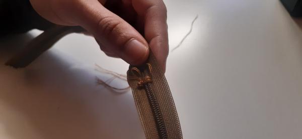 Couture d'un point d'arrêt sur la fermeture éclair pour qu'elle soit plus courte.