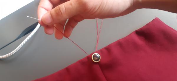 Couture d'un bouton sur le devant de la jupe. Cela était une initiative de ma part et n'était pas dans la vidéo du professeur. J'ai trouvé que cela donnait un cachet supplémentaire à la jupe.