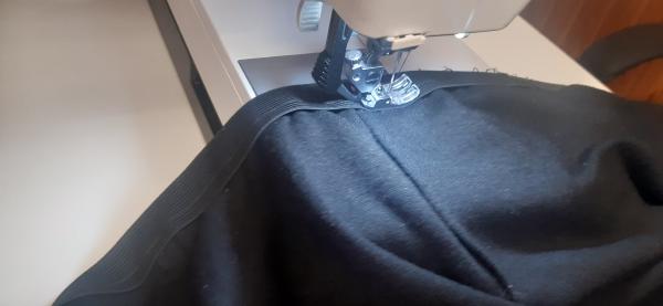 Ici, je couds l'élastique autour de la taille de la jupe.
